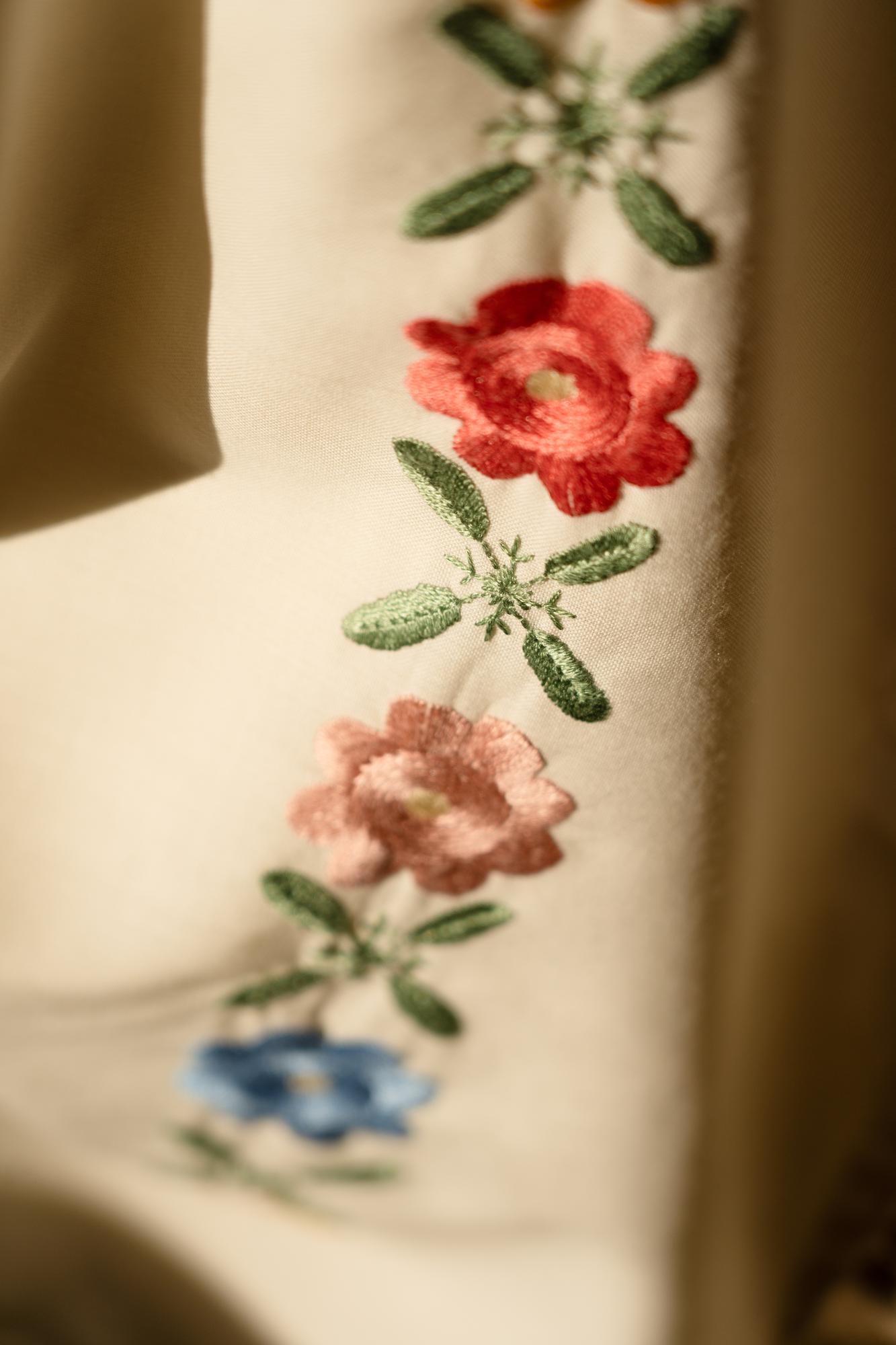 Nahaufnahme einer handgestickten Blüte auf Leinen